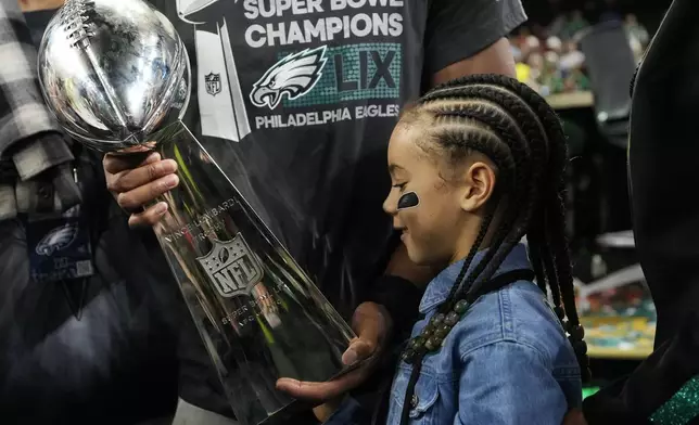 Philadelphia Eagles running back Saquon Barkley's daughter Jada looks at the Vince Lombardi Trophy after the NFL Super Bowl 59 football game against the Kansas City Chiefs, Sunday, Feb. 9, 2025, in New Orleans. (AP Photo/Ashley Landis)