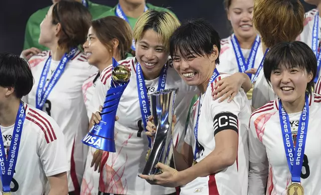 Japan defender Saki Kumagai, center right, holds the trophy as teammate forward Mina Tanaka holds her Most Valuable Player trophy after Japan defeated the United States to win the SheBelieves Cup women's soccer tournament Wednesday, Feb. 26, 2025, in San Diego. (AP Photo/Gregory Bull)