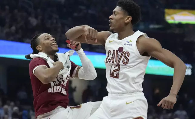 Cleveland Cavaliers forward De'Andre Hunter, right, celebrates with teammate Darius Garland, left, after a basket in the first half of an NBA basketball game against the Minnesota Timberwolves, Monday, Feb. 10, 2025, in Cleveland. (AP Photo/Sue Ogrocki)