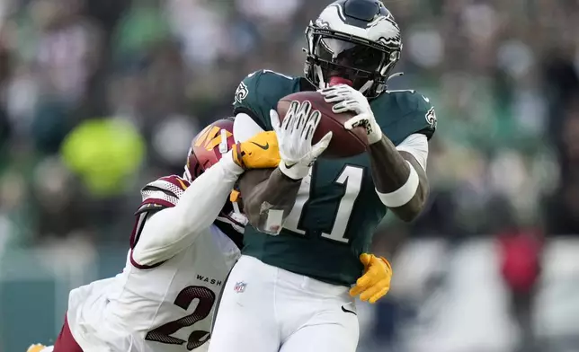 Philadelphia Eagles wide receiver A.J. Brown catches a pass ahead of Washington Commanders cornerback Marshon Lattimore during the first half of the NFC Championship NFL football game, Sunday, Jan. 26, 2025, in Philadelphia. (AP Photo/Seth Wenig)