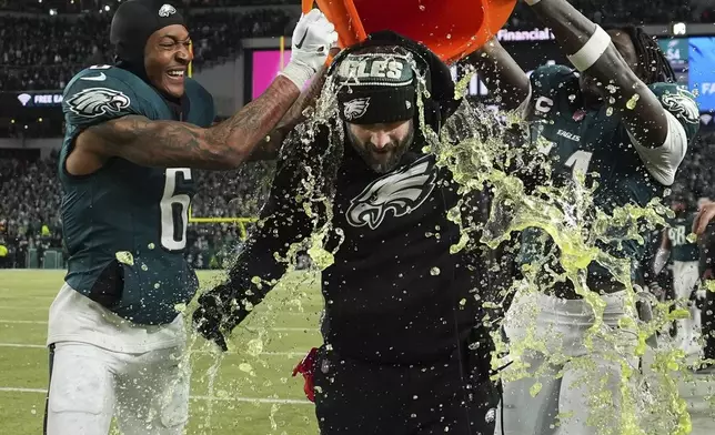 Philadelphia Eagles coach Nick Sirianni, center, is dunked by DeVonta Smith (6) and A.J. Brown (11) during the closing minutes of the second half of the NFC Championship NFL football game against the Washington Commanders, Sunday, Jan. 26, 2025, in Philadelphia. (AP Photo/Matt Slocum)