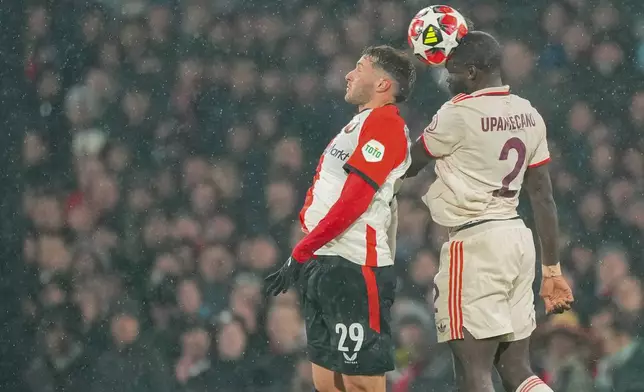 Feyenoord's Santiago Gimenez, left, jumps for the ball with Bayern's Dayot Upamecano during the Champions League opening phase soccer match between Feyenoord and Bayern Munich, at De Kuip Stadium, in Rotterdam, Netherlands, Wednesday, Jan. 22, 2025. (AP Photo/Peter Dejong)
