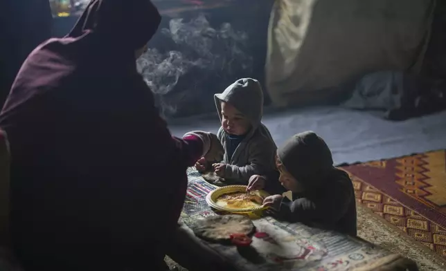 Hanan Okal, 22, feeds her children, Abdul Rahman Al-Najjar, 2, and Qasim Al-Najjar, 4, in a classroom inside the Jabaliya Girls Preparatory School which displaced people use as a shelter in the Jabaliya refugee camp in the northern Gaza Strip, Monday, Feb. 10, 2025. (AP Photo/Abdel Kareem Hana)