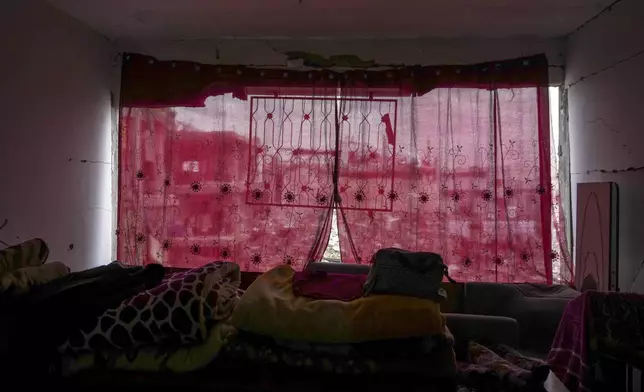 Red fabric is draped over a destroyed wall in the Mossa family home in the Jabaliya refugee camp in the northern Gaza Strip, Friday, Feb. 7, 2025. (AP Photo/Abdel Kareem Hana)