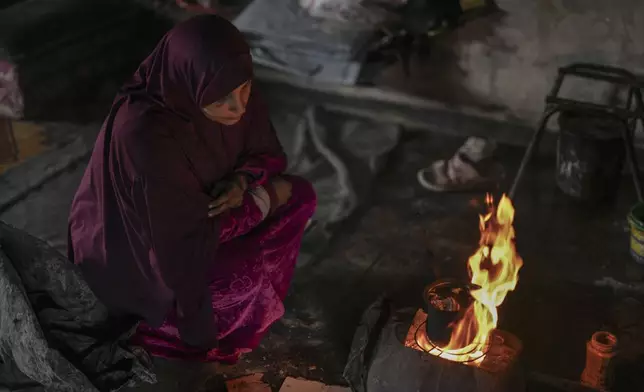 Hanan Okal, 22, prepares tea for her children using an open fire inside a classroom at the Jabaliya Preparatory Girls School in the Jabaliya refugee camp in the northern Gaza Strip, Monday, Feb. 10, 2025. (AP Photo/Abdel Kareem Hana)