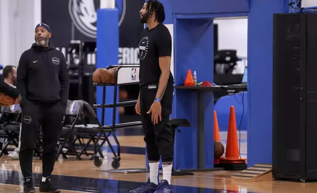 Dallas Mavericks' Anthony Davis, center, talks with team staff at the end of NBA basketball practice at the team's training facility in Dallas, Thursday, Feb. 20, 2025. (AP Photo/Tony Gutierrez)