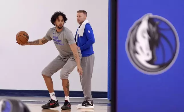 Dallas Mavericks' Dereck Lively II, left, who is recovering from injury works with assistant coach Sean Sweeney, right, at the end of NBA basketball practice at the team's training facility in Dallas, Thursday, Feb. 20, 2025. (AP Photo/Tony Gutierrez)