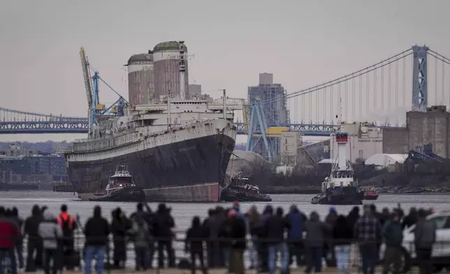 The SS United States is towed down the Delaware River between Pennsylvania and New Jersey, from Philadelphia, Wednesday, Feb. 19, 2025. (AP Photo/Matt Rourke)