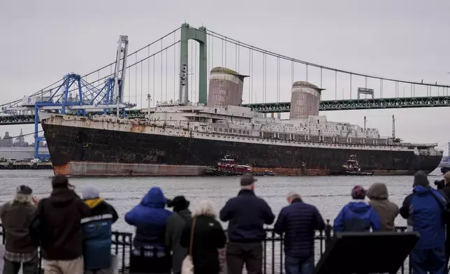 The SS United States is towed down the Delaware River between Pennsylvania and New Jersey, from Philadelphia, Wednesday, Feb. 19, 2025. (AP Photo/Matt Rourke)