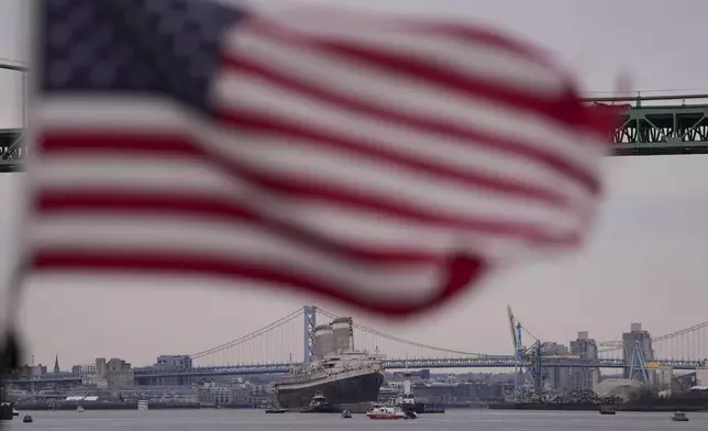 The SS United States is towed down the Delaware River between Pennsylvania and New Jersey, from Philadelphia, Wednesday, Feb. 19, 2025. (AP Photo/Matt Rourke)