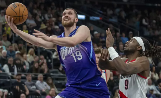 Utah Jazz guard Svi Mykhailiuk (19) goes up with the ball as Portland Trail Blazers forward Jerami Grant (9) defends during the first half of an NBA basketball game Monday, Feb. 24, 2025, in Salt Lake City. (AP Photo/Rick Egan)