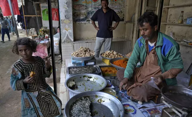A girl buys traditional sweets from a shop at a market in the coastal city of Gwadar, in the southwest Pakistani province of Balochistan, Jan. 13, 2025. (AP Photo/Anjum Naveed)