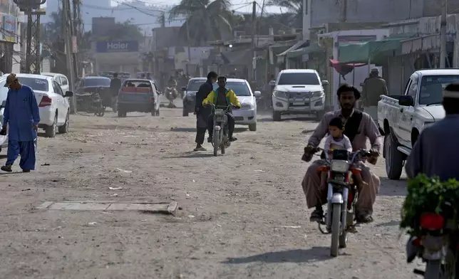 Vehicles and motorcyclists drive on a dusty road in the coastal city of Gwadar, in the southwest Pakistani province of Balochistan, Jan. 13, 2025. (AP Photo/Anjum Naveed)