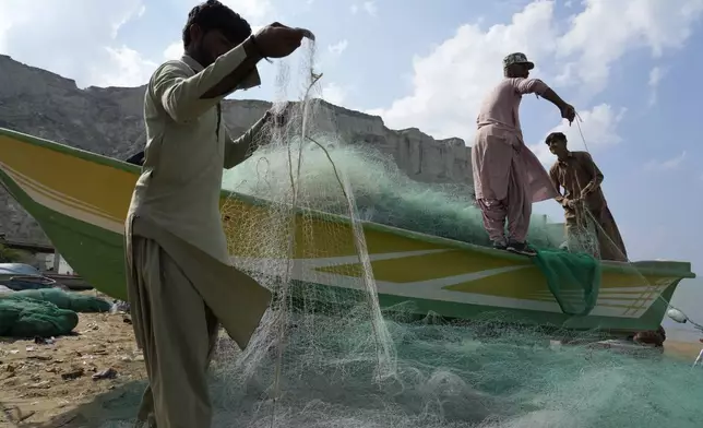 Fishermen repair fishing net in the coastal city of Gwadar, in the southwest Pakistani province of Balochistan, Jan. 13, 2025. (AP Photo/Anjum Naveed)