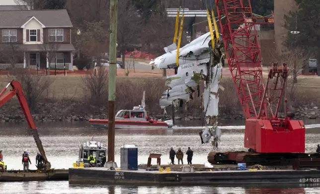 Rescue and salvage crews with cranes pull up the wreckage of an American Airlines jet in the Potomac River from Ronald Reagan Washington National Airport, Monday, Feb. 3, 2025, in Arlington, Va. (AP Photo/Jose Luis Magana)