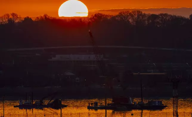 Salvage crews work near the wreckage site in the Potomac River of a mid-air collision between an American Airlines jet and a Black Hawk helicopter, at Ronald Reagan Washington National Airport, Tuesday, Feb. 4, 2025, in Arlington, Va. (AP Photo/Ben Curtis)