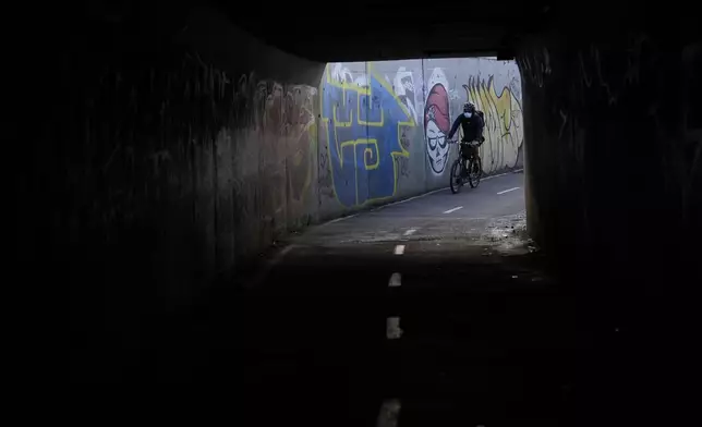 A commuter cycles along an empty street on the city's annual car-free day in Bogota, Colombia, Thursday, Feb. 6, 2025. (AP Photo/Fernando Vergara)