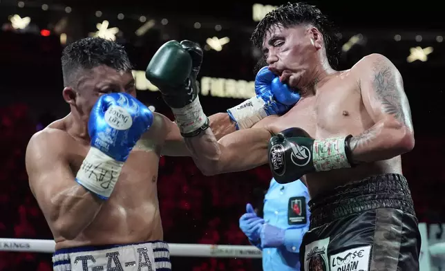 Isaac Cruz, left, hits Angel Fierro in a super lightweight boxing match Saturday, Feb. 1, 2025, in Las Vegas. (AP Photo/John Locher)