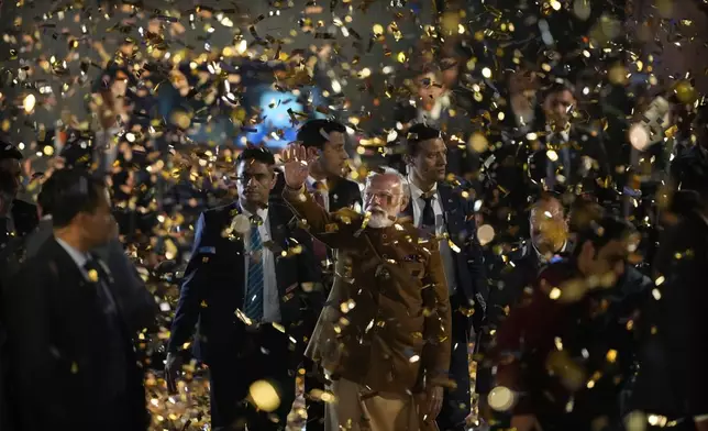 Supporters of Bharatiya Janata Party throw confetti as Indian Prime Minister Narendra Modi, center, arrives at party headquarters to celebrate party's win at Delhi state elections in New Delhi,India, Saturday, Feb. 8, 2025. (AP Photo/Manish Swarup)
