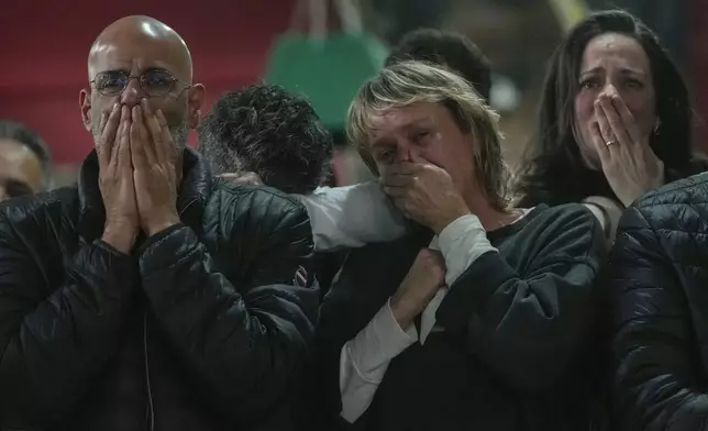Friends and relatives of Ohad Ben Ami and Eli Sharabi, who were taken from kibbutz Beeri on Oct.7, 2023 attack, react as they watch the live broadcast of their release from Hamas captivity in Gaza, at the Kibbutz Beeri, Israel, Saturday, Feb. 8, 2025, as part of the Israel-Hamas ceasefire deal. (AP Photo/Maya Alleruzzo)