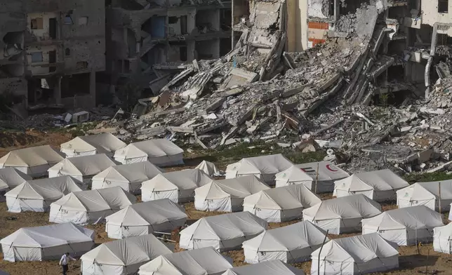 A tent camp for displaced Palestinians is set up next to destroyed buildings following the Israeli air and ground offensive in Jabaliya, Gaza Strip, Thursday, Feb. 6, 2025. (AP Photo/Abdel Kareem Hana)