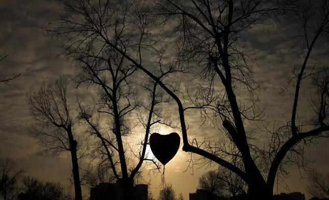 Students hold a heart-shaped balloon as they prepare to end the blockage of the Bridge of Freedom and protest over the collapse of a concrete canopy that killed 15 people more than two months ago, in Novi Sad, Serbia, Sunday, Feb. 2, 2025. (AP Photo/Armin Durgut)