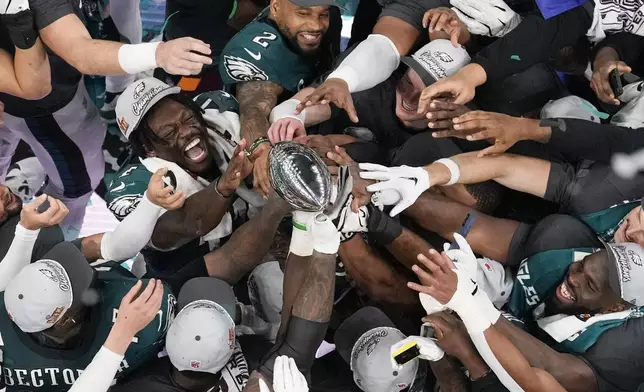 Philadelphia Eagles players celebrate with the Vince Lombardi Trophy after the Eagles won the NFL Super Bowl 59 football game against the Kansas City Chiefs, Sunday, Feb. 9, 2025, in New Orleans. (AP Photo/David J. Phillip)