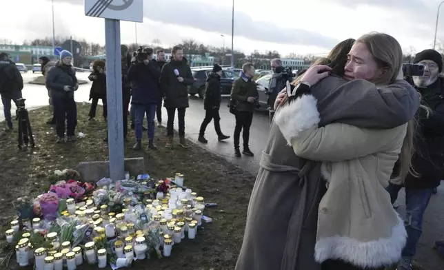 People gather at a makeshift memorial near the scene of a shooting on the outskirts of Orebro, Sweden, Wednesday, Feb. 5, 2025. (AP Photo/Sergei Grits)