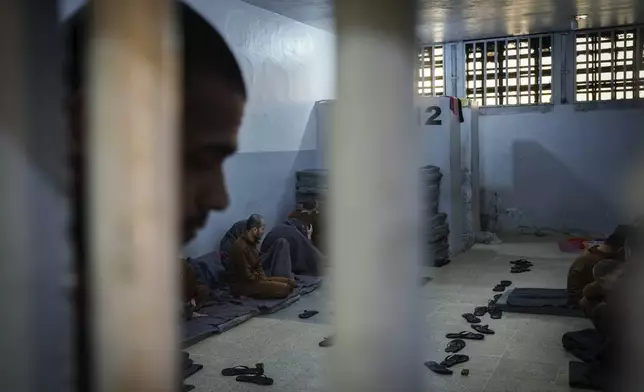 Inmates accused of being an Islamic State (ISIS) fighters sit inside a cell at the Syrian Democratic Forces-run Gweiran Prison, now called Panorama, in Hassakeh, northeastern Syria, Friday, Jan. 31, 2025. (AP Photo/Bernat Armangue)