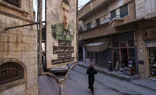 A poster honoring the late Julian Fahmi, a Syriac Orthodox fighter killed in action, is displayed on a street in the northeastern Syrian city of Hassakeh, Monday, Jan. 27, 2025. (AP Photo/Bernat Armangue)