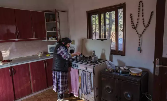 A large rosary hangs on a wall as Raheel Yelda Nissan, a Syriac Orthodox Christian, prepares tea in the northeastern Syrian village of Tel Tal, which is currently controlled by the U.S.-backed, Kurdish-led Syrian Democratic Forces, Monday, Jan. 27, 2025. (AP Photo/Bernat Armangue)