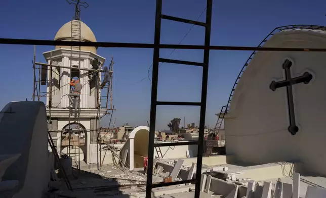 Workers rebuild the rooftop of a Syriac Orthodox church in the northeastern Syrian city of Hassakeh, Monday, Jan. 27, 2025. (AP Photo/Bernat Armangue)