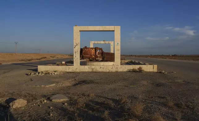 The wreckage of an armored vehicle belonging to the Islamic State group is displayed as a symbol of victory on a road in the northeastern Syrian province of Hassakeh, which is currently controlled by the U.S.-backed, Kurdish-led Syrian Democratic Forces, Monday, Jan. 27, 2025. (AP Photo/Bernat Armangue)