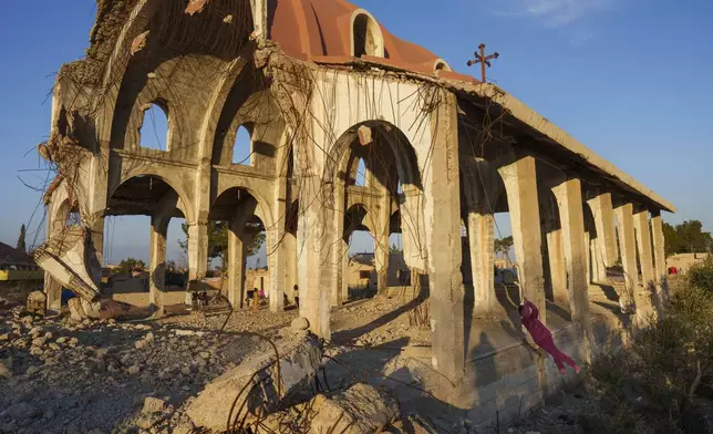 Children play in the ruins of the Church of Virgin Mary, which was destroyed by the Islamic State group in 2015, in the northeastern Syrian village of Tel Nasri, which is currently controlled by the U.S.-backed, Kurdish-led Syrian Democratic Forces, Monday, Jan. 27, 2025. (AP Photo/Bernat Armangue)