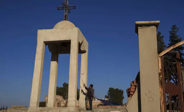 Ishaq Nissan, a Syriac Orthodox Christian, rings the church bell in the northeastern Syrian village of Tel Tal, which is currently controlled by the U.S.-backed, Kurdish-led Syrian Democratic Forces, Monday, Jan. 27, 2025. (AP Photo/Bernat Armangue)
