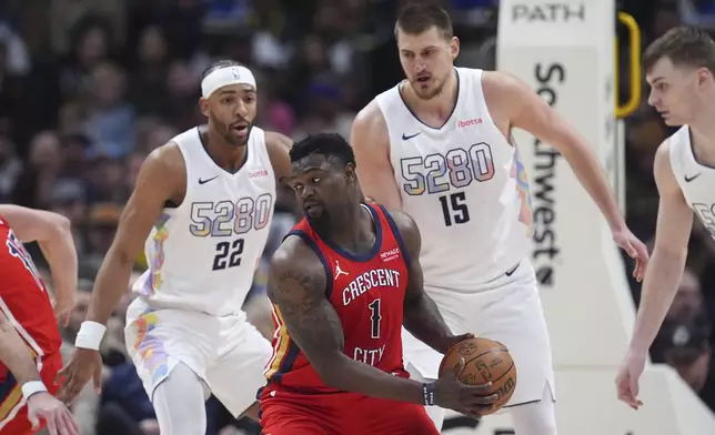 New Orleans Pelicans forward Zion Williamson, front, looks to pass the ball as Denver Nuggets forward Zeke Nnaji, back left, and center Nikola Jokic defend in the first half of an NBA basketball game Wednesday, Feb. 5, 2025, in Denver. (AP Photo/David Zalubowski)
