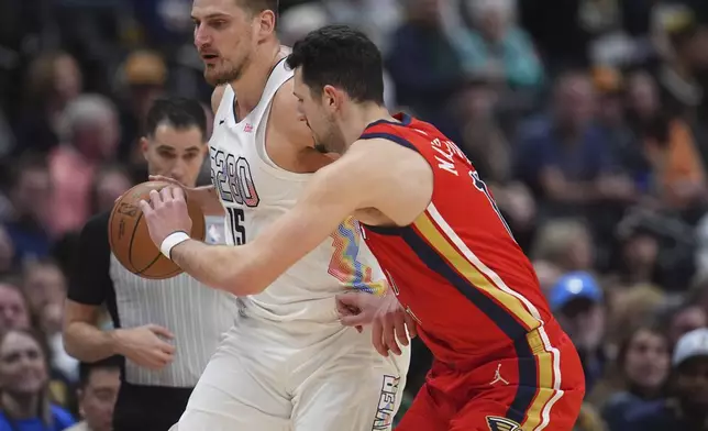 Denver Nuggets center Nikola Jokic, back, brings the ball up the court as New Orleans Pelicans center Karlo Matkovic defends in the first half of an NBA basketball game Wednesday, Feb. 5, 2025, in Denver. (AP Photo/David Zalubowski)