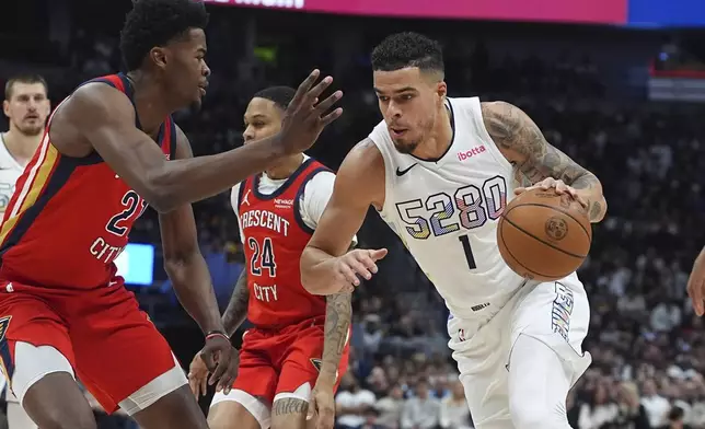 Denver Nuggets forward Michael Porter Jr., right, drives to the basket as New Orleans Pelicans center Yves Missi defends in the first half of an NBA basketball game Wednesday, Feb. 5, 2025, in Denver. (AP Photo/David Zalubowski)