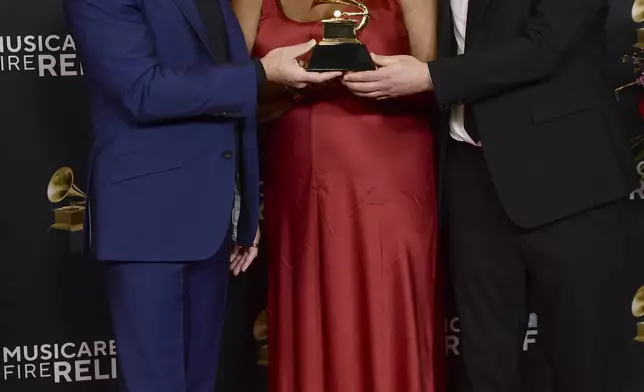 Matthew Heineman, from left, Lauren Domino and Joedan Okun pose in the press room with the award for best music film for "American Symphony" during the 67th annual Grammy Awards on Sunday, Feb. 2, 2025, in Los Angeles. (Photo by Richard Shotwell/Invision/AP)