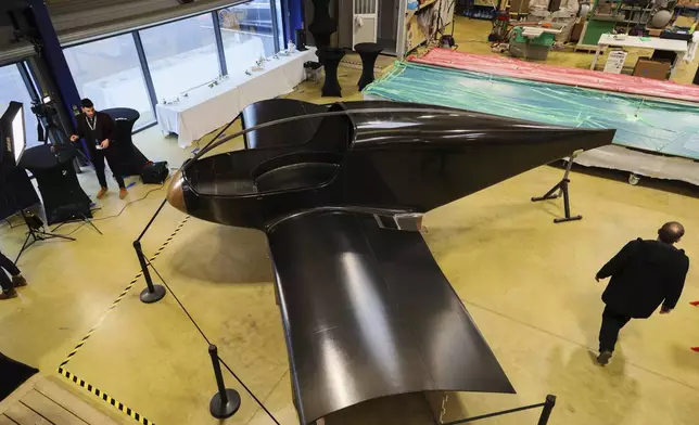 The Climate Impulse, a plane powered by liquid hydrogen, is displayed in a hangar in Les Sables d'Olonne, France on Thursday, Feb. 13, 2025. (AP Photo/Yohan Bonnet)