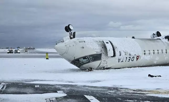 In this image provided by the National Transportation Safety Board, the wreckage of a Delta Air Lines jet rests upside down, Tuesday, Feb. 18, 2025, after it burst into flames and flipped upside down as it tried to land on Feb. 17, at Toronto Pearson International Airport in Mississauga, Ontario. (National Transportation Safety Board via AP)