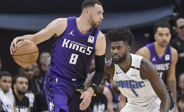 Sacramento Kings guard Zach LaVine (8) is guarded by Orlando Magic forward Jonathan Isaac (1) during the first half of an NBA basketball game in Sacramento, Calif., Wednesday, Feb. 5, 2025. (AP Photo/Randall Benton)