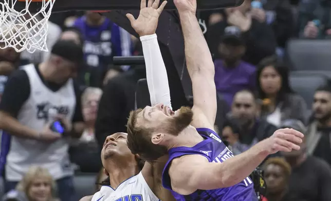 Orlando Magic forward Paolo Banchero (5) and Sacramento Kings forward Domantas Sabonis battle for a rebound during the first half of an NBA basketball game in Sacramento, Calif., Wednesday, Feb. 5, 2025. (AP Photo/Randall Benton)