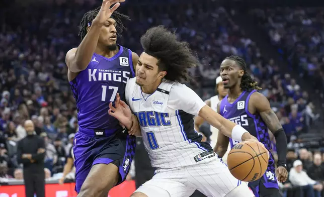 Orlando Magic guard Anthony Black (0) drives past Sacramento Kings center Isaac Jones (17) during the first half of an NBA basketball game in Sacramento, Calif., Wednesday, Feb. 5, 2025. (AP Photo/Randall Benton)