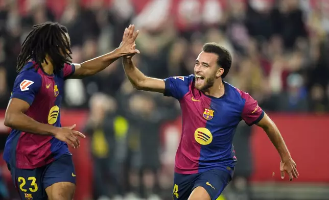 Barcelona's Eric Garcia celebrates with Jules Kounde, left, after scoring his side's fourth goal during a Spanish La Liga soccer match between Sevilla and FC Barcelona at the Ramon Sanchez Pizjuan stadium in Seville, Spain, Sunday, Feb. 9, 2025. (AP Photo/Jose Breton)