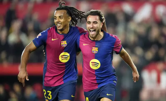 Barcelona's Eric Garcia celebrates with Jules Kounde, left, after scoring his side's fourth goal during a Spanish La Liga soccer match between Sevilla and FC Barcelona at the Ramon Sanchez Pizjuan stadium in Seville, Spain, Sunday, Feb. 9, 2025. (AP Photo/Jose Breton)