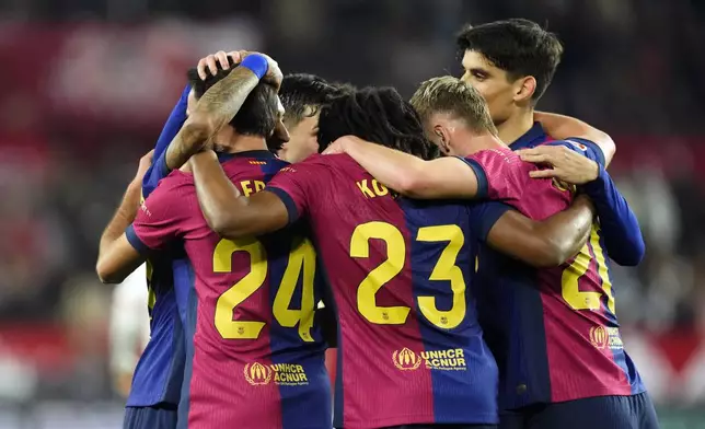 Barcelona's Eric Garcia, foreground left, celebrates with his teammates after scoring his side's fourth goal during a Spanish La Liga soccer match between Sevilla and FC Barcelona at the Ramon Sanchez Pizjuan stadium in Seville, Spain, Sunday, Feb. 9, 2025. (AP Photo/Jose Breton)
