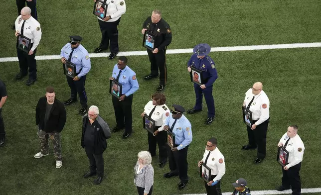 First responders hold photos of victims from the New Years Day terrorist attack before the NFL Super Bowl 59 football game between the Kansas City Chiefs and the Philadelphia Eagles, Sunday, Feb. 9, 2025, in New Orleans. (AP Photo/David J. Phillip)