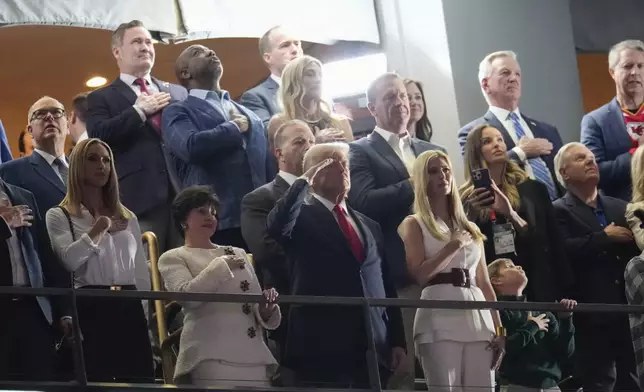 President Donald Trump, center, stands for the national anthem next to his daughter Ivanka Trump and New Orleans Saints owner Gayle Benson before the NFL Super Bowl 59 football game between the Kansas City Chiefs and the Philadelphia Eagles, Sunday, Feb. 9, 2025, in New Orleans. (AP Photo/George Walker IV)