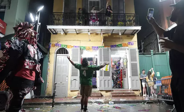 A Philadelphia Eagles fan gestures toward people on a balcony in the French Quarter during the NFL Super Bowl 59 football game between the Kansas City Chiefs and the Eagles, Sunday, Feb. 9, 2025, in New Orleans. (AP Photo/Julia Demaree Nikhinson)